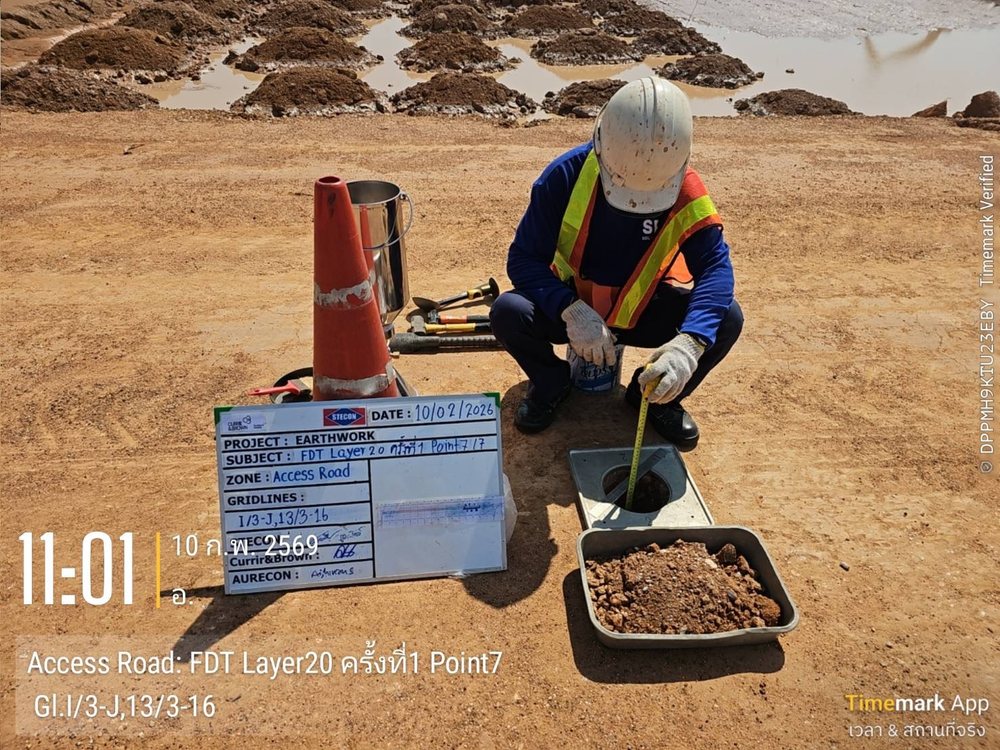 เจ้าหน้าที่ SPN วัดความลึกหลุมทดสอบ Field Density Test ในงานถมบดอัดชั้นที่ 20 พร้อมป้ายบันทึกชั้นบดอัดและจุดทดสอบ