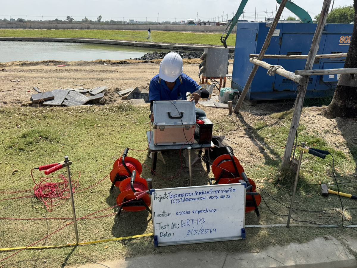 กระดานบันทึกงานทดสอบความต้านทานไฟฟ้าของดินโครงการท่อก๊าซ ระบุจุดทดสอบและวันที่ ตั้งอยู่หน้าพื้นที่ทดสอบข้างถนน